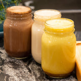Golden, chocolate, and plain plant milks in mason jars.